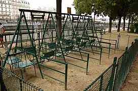Balançoires à double siège dans le square des Batignolles à Paris.