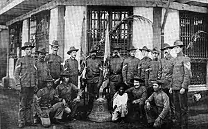 Groupe d'hommes, un garçon et une cloche d'église sur le sol