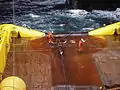 Deux membres d'équipage sur la zone du treuil de manutention de l'AHTS Balder Viking Transocean Arctic