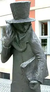 Sculpture intitulée Hoffmann et son chat, située devant le théâtre E.T.A. Hoffmann de Bamberg. Un personnage inquiétant en haut de forme et au visage indistinct tient sur son épaule droite un chat et porte un livre imposant sous son bras gauche.