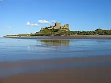 Photo d'un château situé sur un promontoire rocheux surmontant la mer.