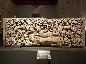 Linteau représentant le dieu hindou Nārāyaṇa dormant sur le serpent Śeṣa au milieu de l'Océan de lait (temple Ku Sia Taeng, Buriram), pierre, XIIe siècle