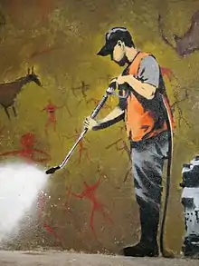 Un graffiti au sujet de l'effacement des graffitis, par Banksy, à Londres. Les graffitis effacés par l'agent d'entretien sont des peintures rupestres