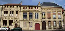 Photographie de trois façades d'immeubles en pierre.