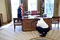 Barack Obama regardant le panneau mobile avant sous le regard de Caroline Kennedy dont le frère John, enfant, jouait sous ce bureau.