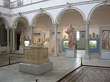 Vue de la salle de Carthage avec l'autel de la Gens Augusta au premier plan et la statue d'impératrice à l'arrière-plan.