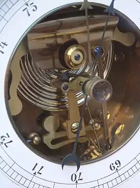 Baromètre anéroïde, début XXe siècle, on voit la capsule de Vidi et les leviers amplificateurs.