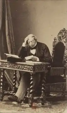 Représentation du baron James de Rothschild, assis à un bureau et consultant un document