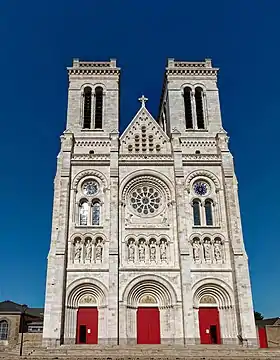 La façade de la basilique, sur la place des Enfants-Nantais, au centre de laquelle est érigée une statue équestre de Jeanne d'Arc signée Charles-Auguste Lebourg (1829-1906).