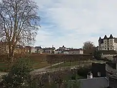 Photographie en couleurs d'un parc et d'un château en surplomb.