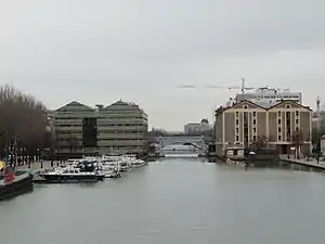 Bassin de la Villette en hiver, depuis la passerelle centrale. Entre les anciens magasins généraux, au fond, vue sur les anciens Grands Moulins de Pantin.