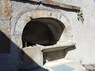 Bassin du hameau de l'Église, incrusté dans le mur du presbytère.