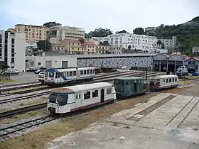 Vue du dépôt avec motrice X 97050, 2 remorques "Billard" réformés, "la bête de Calvi" tracteur n° 114 au milieu, Bâtiment administratif à étages à gauche. A droite remises à autorails et atelier.