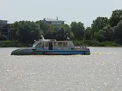 Photographie d'un petit bateau sur la Garonne grise.