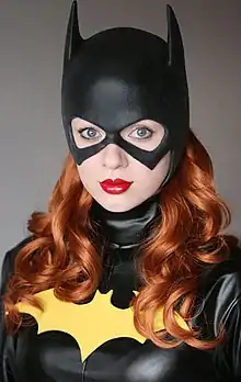 Photographie couleur du buste d'une jeune femme déguisée en Batgirl.