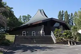 Vue d’un édifice religieux avec un toit en ardoises aux courbes modernes.