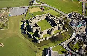 Vue aérienne d'un château carré à deux enceintes concentriques et plusieurs tours.