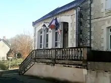 Photographie en couleurs d'un bâtiment décoré des drapeaux européen et français.