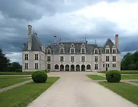 Photographie en couleur représentant la cour et la façade d'un château.