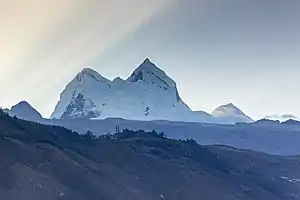 Montagne enneigée avec une lumière rasante venant de l'arrière