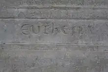 Détail d'une pierre gravée avec une inscription difficile d'interprétation