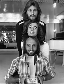 Robin (22/12/1949-20/05/2012) (au milieu) et Maurice Gibb (22/12/1949-12/01/2003) (en bas), avec leur frère Barry Gibb (en haut), The Bee Gees, en 1977.