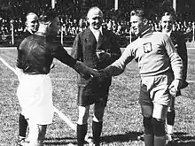 Photographie en noir et blanc de deux joueurs de football se serrant la main.