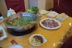 Fondue au chien de la minorité Buyei du :bourg de Huajiang (zh) à Pékin.