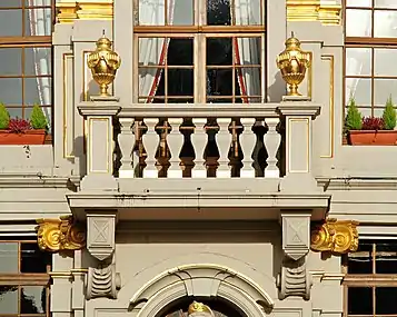 Le balcon orné de vases dorés.