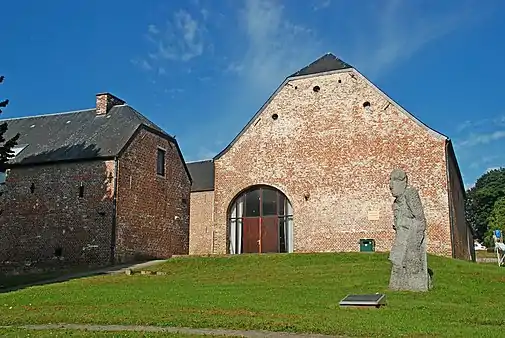 La statue devant la façade orientale de grange.