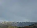 L'extrémité méridionale de la chaîne de Belledonne vue depuis Grenoble avec de gauche à droite la Grande Lance de Domène, le Grand Colon et la Croix de Chamrousse coiffée des gares d'arrivée des remontées mécaniques.