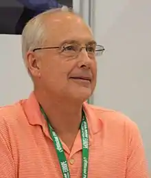 Homme blanc avec des lunettes et des cheveux blancs.