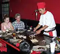 Un chef préparant cuisinant façon teppanyaki.