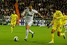 Photo de Karim Benzema en pleine conduite de balle face aux joueurs de Villareal.