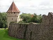 Tour B, ronde, avec corbeaux, arcs et une gargouille.