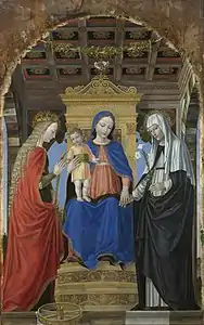 Image d'une peinture montrant la Vierge assise sur un trône avec l'Enfant debout sur ses genoux, est flanquée de deux saintes. La scène se déroule dans une sorte de loggia en bois, caractérisée par un plafond lacunaire avec des rosettes.