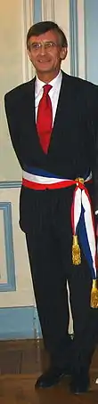 Maire français portant l'écharpe en ceinture.