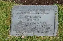 Photo agrandie d'une pierre commémorative grise avec des inscriptions.