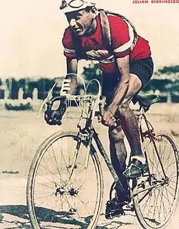 Photographie d'un cycliste sur son vélo, portant un maillot rouge.
