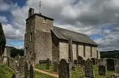 Plan large sur l’église, avec devant le cimetière et la croix