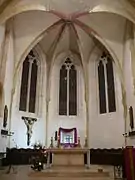 Vue intérieure du chœur d'une église. Croisée de voûte décorée et peinte.