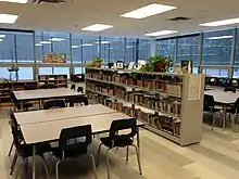 Une bibliothèque scolaire au Québec. Tables de travail et rayonnages.