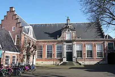 Salle de réunion des Cloveniers, aujourd'hui bibliothèque municipale d'Haarlem, avec une plaque commémorative au-dessus de la porte, placée 200 ans après le siège de Haarlem, durant lequel de nombreux Cloveniers sont morts en défendant la ville.
