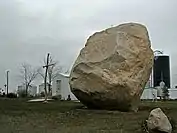Très gros rocher posé sur le sol.