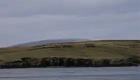 Extrémité Sud de l'île de Bigga avec les ruines d'une maison et les sommets de Mainland au dernier plan.