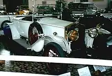 Photo d'une voiture blanche à carrosserie ouverte exposée dans un musée.