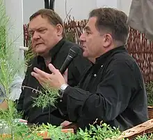 Piotr Bikont avec un journaliste tenant un micro