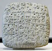 Tablette blanche carrée inscrite de signes cunéiformes. Musée du Louvre.