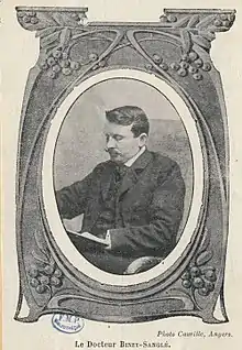Photo noir et blanc en médaillon d'un homme avec une moustache.
