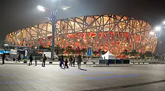 Stade National de Pékin; "le nid d'oiseau" de nuit. Herzog & de Meuron, institut China Architecture Design & Research Group, 2003. Artiste consultant : Ai Weiwei.